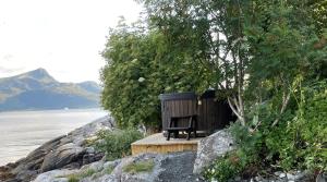 LarsnesKråen Gard的木凳坐在水体边