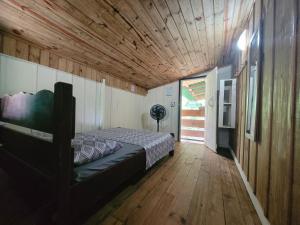 蜜岛克洛铎露营旅馆的一间卧室设有一张床和木制天花板