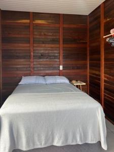 南圣弗朗西斯科Refúgio Litorâneo em São Chico-Ervino的卧室配有白色的木墙床