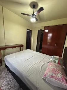 瓜拉派瑞Residencial Copacabana的一间卧室配有一张带吊扇的床