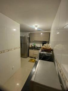 大伊瓜巴Casa Paraíso Costeiro的一间带白色墙壁的厨房和一间带冰箱的厨房