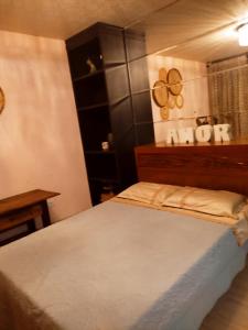 伊达贾伊Casa com Piscina的一间卧室配有一张床和一个木制床头板