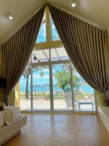 象岛乔客度假酒店的客厅设有大窗户和窗帘
