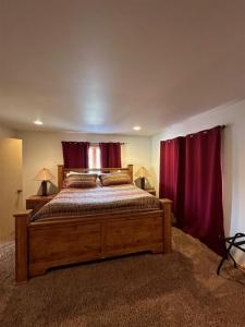六月湖Rr-johnson Suite 2的一间卧室配有一张带红色窗帘的大型木床