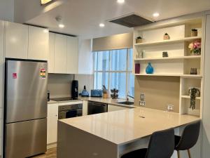 悉尼Location Location Executive Apartment的厨房配有不锈钢冰箱和台面