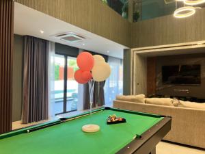农布Minho Villa Luxury Pattaya的客厅配有带气球的台球桌