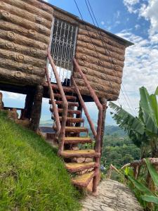 Hermosa cabaña para parejas cerca a Tuluá con jacuzzi的一座木房子,位于一座小山上,设有楼梯