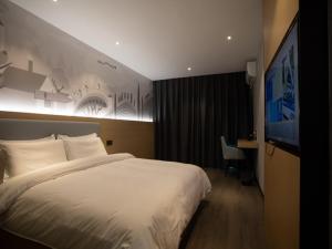 怀化尚客优连锁湖南怀化鹤城区高铁南站店的酒店客房设有一张大床和一张书桌。