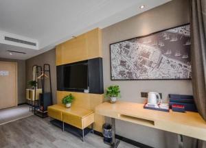 郑州郑州高新区总部企业基地兰欧尚品酒店的客房设有书桌和墙上的电视