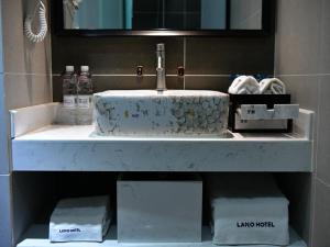 郑州郑州高新区总部企业基地兰欧尚品酒店的浴室的柜台设有水槽和镜子