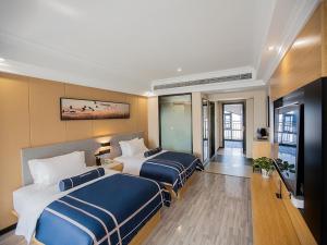 黄石黄石黄石港区摩尔城兰欧尚品酒店的酒店客房设有两张床和电视。