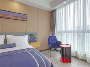海盐嘉兴海盐科技城兰欧酒店的酒店客房,配有一张床和一张蓝色椅子