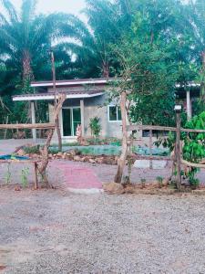Baan Namthip Homestay Trang บ้านน้าทิพย์ โฮมสเตย์ตรัง的房屋前的木栅栏