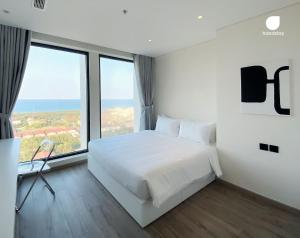 莲三Căn hộ VIP Phú Yên的卧室设有白色的床和大窗户