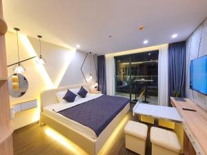 莲三Căn hộ VIP Phú Yên的一间卧室配有一张床、一张书桌和一台电视