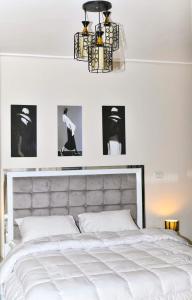 Kafr Abū ʼumaydahشقه فندقية للايجار الترا مودرن的卧室配有一张白色床,墙上挂有照片