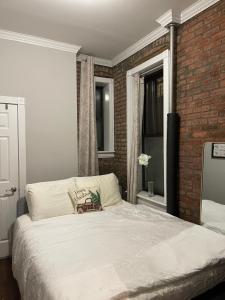 纽约Private one bedroom one bathroom的卧室配有白色的砖墙床