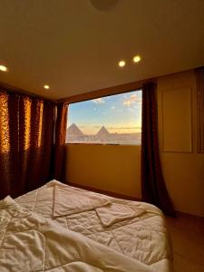 开罗Pyramids Pride Inn的一间卧室设有一张床和一个大窗户