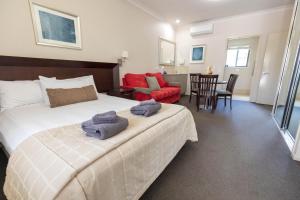 HighfieldsHighfields Motel Toowoomba的一间卧室配有一张床,上面有两条毛巾