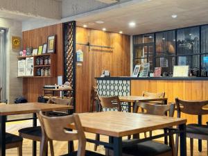 台南Roaders Hotel Tainan ChengDa的一间带木桌椅的餐厅和一间酒吧