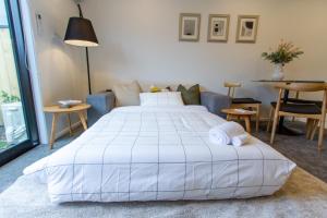 基督城1 bed comfort in the heart of Chch的卧室配有一张白色的大床和一张沙发。