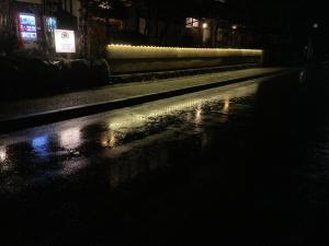 京都旅荘茶谷日式旅馆的街上的一条夜间潮湿街道上灯火通明