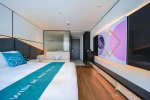 深圳蓬客精品酒店（深圳罗湖宝能中心笋岗地铁站店）的一间卧室设有一张大床和一面墙