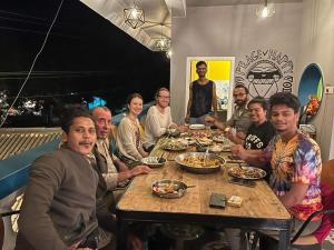 黎明之村Unearth Hostel (Pondicherry)的一群坐在桌子旁吃食物的人