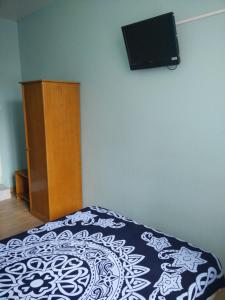 佩皮尼昂贝瑞酒店的卧室配有一张床,墙上配有电视。