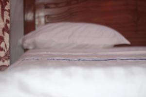 丰博尼Faradel Motel的一张带白色枕头的床铺的壁橱
