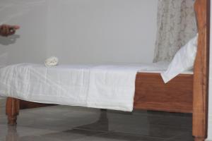 丰博尼Faradel Motel的一张小床,上面有白色的毯子