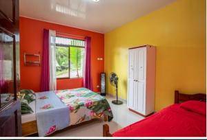 奎波斯城Yellow House的一间卧室拥有橙色的墙壁、一张床和窗户