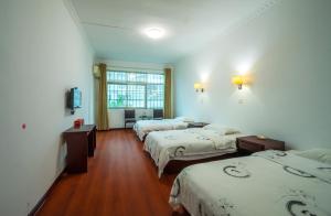 张家界张家界大庸家民宿 DYJ Hostel的酒店客房设有三张床和窗户。
