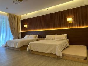 纳苏格布The Beach Suites at Pico De Loro的酒店客房设有两张床和窗户。