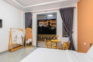 大叻Nhat Minh Hotel Dalat的一间卧室配有一张床、一张桌子和一个窗户。
