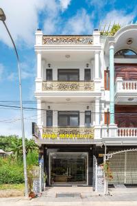 大叻Nhat Minh Hotel Dalat的一座白色的大建筑,上面有标志