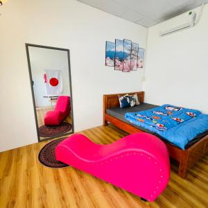 朱笃Nhà nghỉ Bảo Trâm的一间卧室配有一张带红色大座椅的床