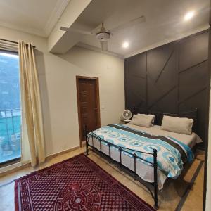 伊斯兰堡Urban Oasis 2-Bedroom, Main Margallah Rd的一间卧室设有一张床和一个大窗户