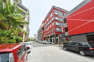 马六甲MRC Hotel Melaka Raya的一条街道,汽车停在大楼的一侧