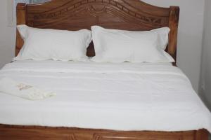 丰博尼Faradel Motel的一张带白色床单和枕头的床