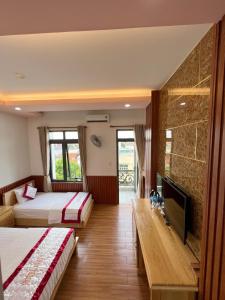边和Hotel Như ý Biên Hòa的酒店客房设有两张床和一台平面电视。