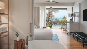 曾蒙海滩Kimpton Kitalay Samui, an IHG Hotel的一间带白色浴缸和大窗户的浴室