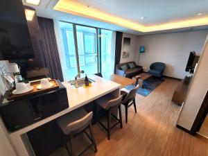 釜山W Residence Hotel的酒店客房设有厨房和客厅。