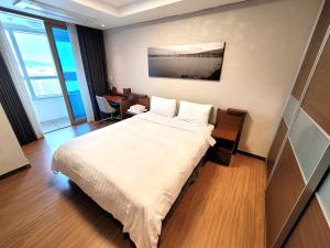 釜山W Residence Hotel的配有一张床和一张书桌的酒店客房