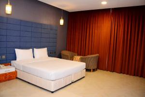 塞拉莱Samharam Resort Salalah的一间卧室配有床和红色窗帘