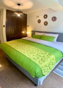 库斯科Cusco Magico 2 - Aparthotel Condominio Las Torres Kayser II的一间卧室配有一张带绿色床单的大床