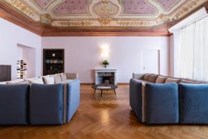 热那亚The Seven Residence的客厅配有蓝色椅子和壁炉