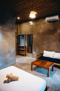 卢纳将军城The Ohm Siargao Resort的配有床、桌子和沙发的房间