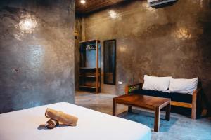 卢纳将军城The Ohm Siargao Resort的配有床、桌子和沙发的房间