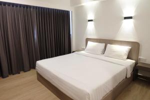 彭世洛友通酒店的卧室配有一张带两个枕头的大白色床